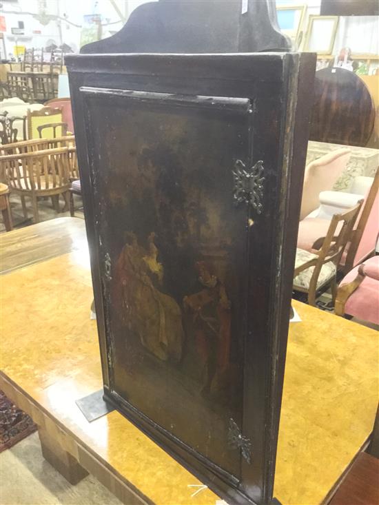 18C hanging corner cupboard, the panelled door painted lovers in a landscape